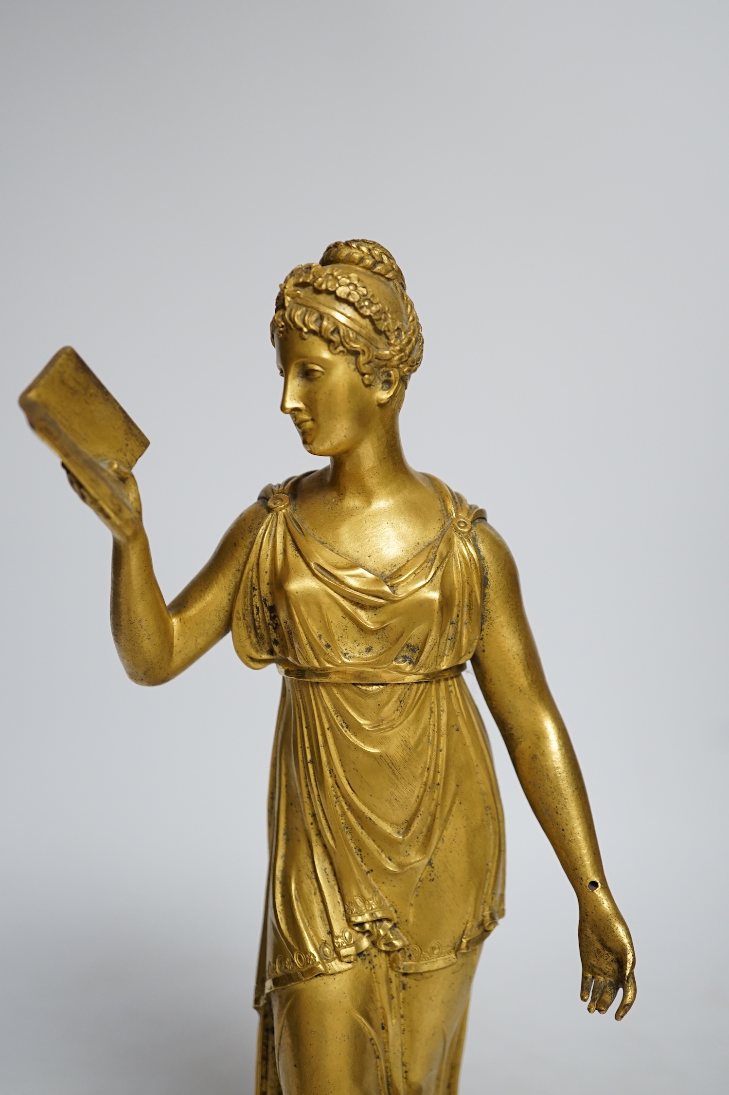 A 19th century French ormolu figure of a woman reading, on a two-piece grey marble base, 33cm high